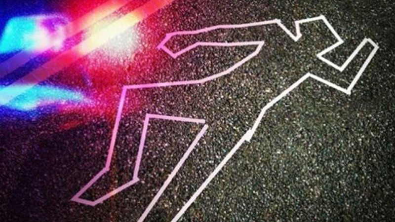 Desenho de contorno de corpo em asfalto com luzes de polícia refletindo.