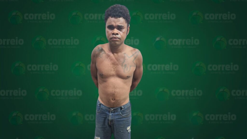 Homem de pele escura, sem camisa e de jeans, com tatuagens, em pé contra um fundo verde com o logo "correio".