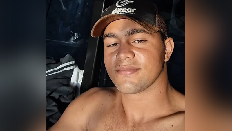 Jovem com boné de trucker Elitear, sem camisa, olhando para a câmera.