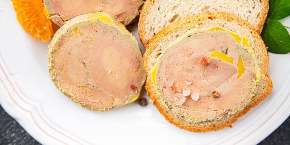 Fatias de terrine ou patê gourmet servidas em pão torrado com sal grosso.