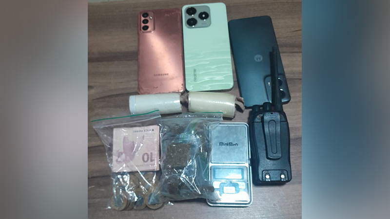 Objetos apreendidos: três celulares, dois pacotes cilíndricos, dinheiro, substância vegetal e balança digital, com um rádio comunicador.
