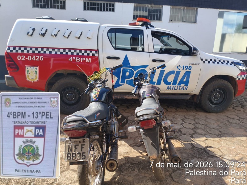 Duas motocicletas estacionadas em frente a uma caminhonete da Polícia Militar.