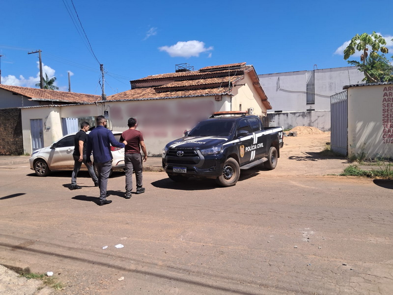 Viaturas da Polícia Civil e agentes em uma rua de bairro residencial.