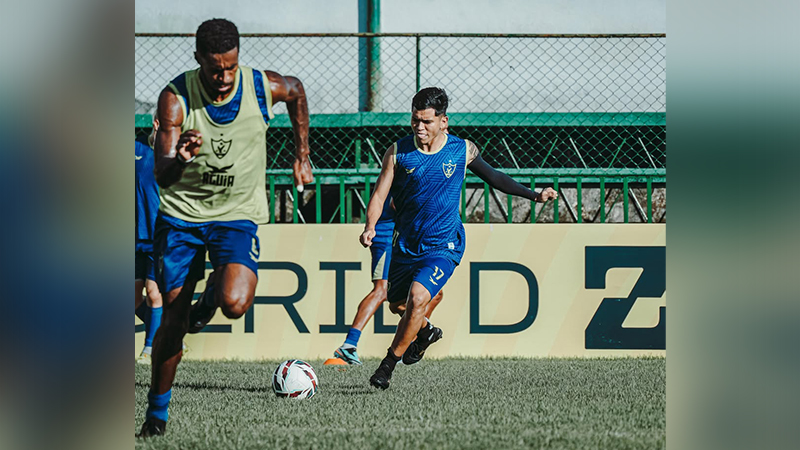 Dois jogadores de futebol em ação no campo gramado.