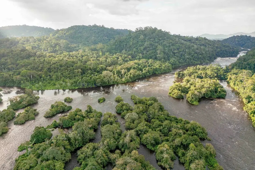 Vista aérea de um rio largo cortando uma floresta densa e verde, com diversas ilhas pequenas.