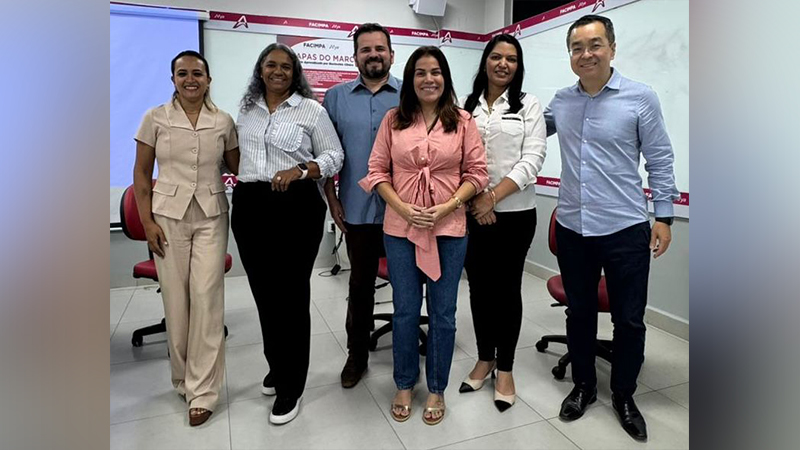 Grupo de seis pessoas sorrindo em uma sala de reunião com o logo FACIMPA ao fundo.