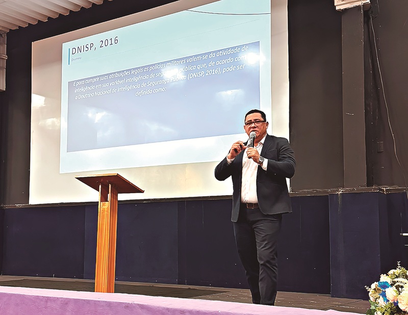 Homem de terno palestrando em frente a um telão com texto sobre DNISP 2016.