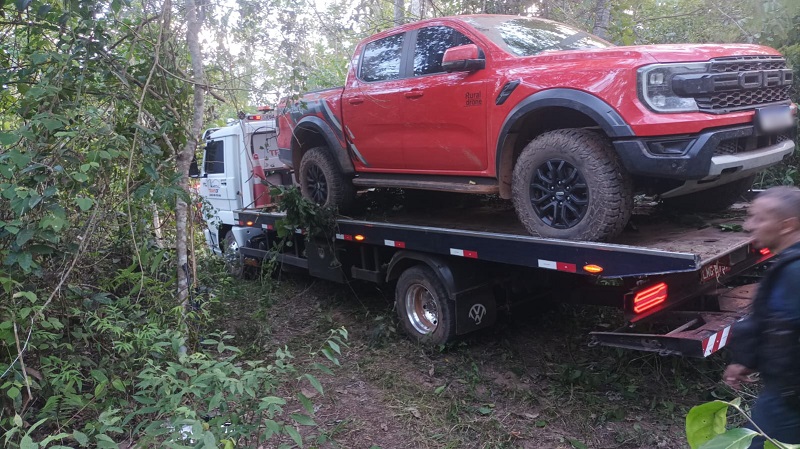 Camionete Ford Ranger Raptor vermelha sendo transportada por um guincho em área de mata.