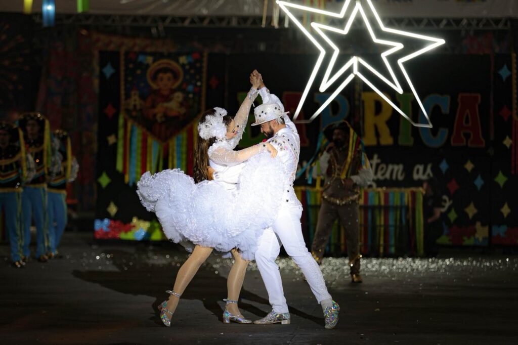 Casal de dançarinos de quadrilha junina vestidos de branco em apresentação