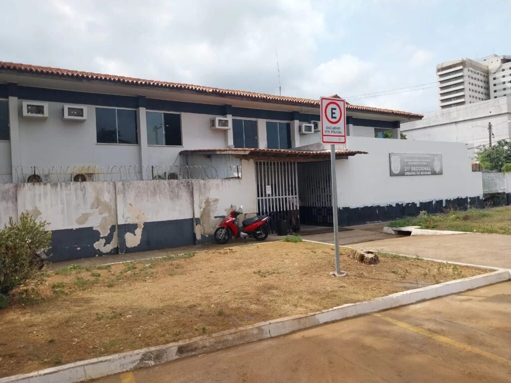 Fachada do prédio da 21ª Seccional Urbana de Marabá com uma moto vermelha estacionada na frente.