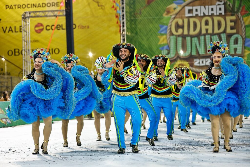 Dançarinos de quadrilha em apresentação de festa junina com roupas coloridas e chapéus decorados