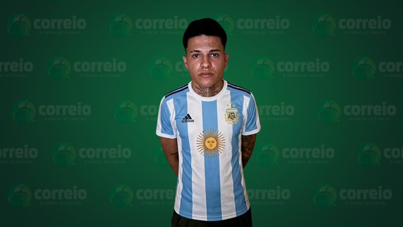 Jovem de pele clara com tatuagem no pescoço usando uma camisa oficial da seleção argentina de futebol.