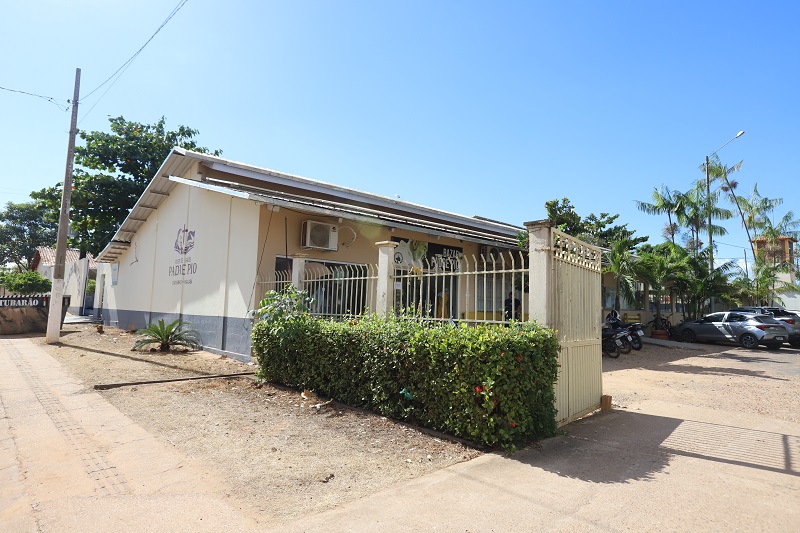 Fachada do Bazar Padre Pio em um dia ensolarado com céu azul.