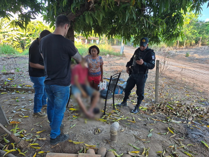 Cena externa com agentes de segurança abordando ou prestando assistência a uma família no campo