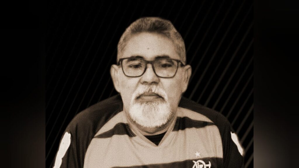 Homem de meia-idade com barba branca e óculos vestindo camisa do Flamengo.