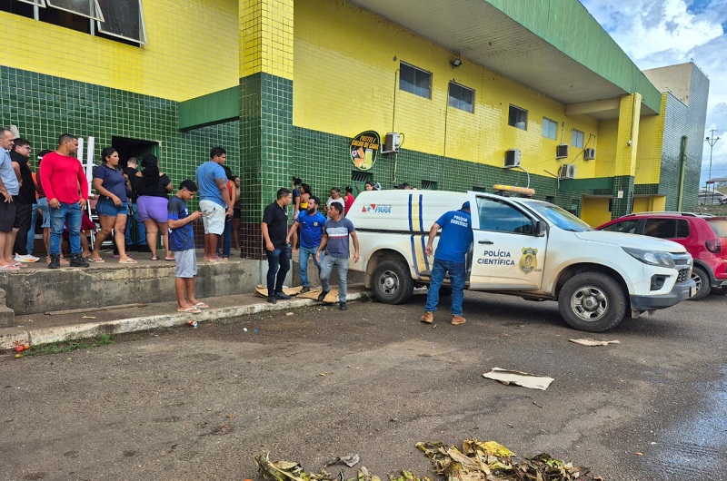 Viaturas da Polícia Científica do Pará estacionadas em frente a um prédio com fachada amarela e verde.