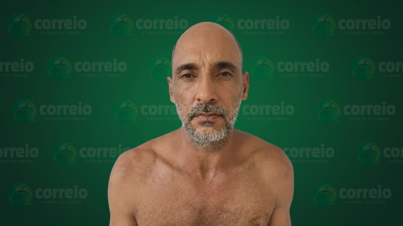 Retrato de um homem de meia-idade com barba rala, sem camisa, posando em frente a um fundo verde com o logo do site Correio.