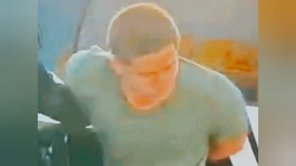Retrato de um homem com cabelos curtos vestindo uma camiseta verde de frente para a câmera.