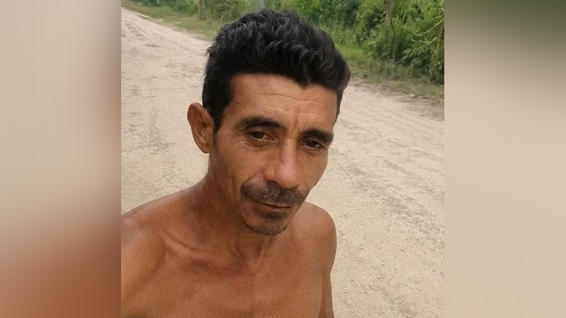 Homem de meia-idade posando para selfie em uma estrada de terra rural.
