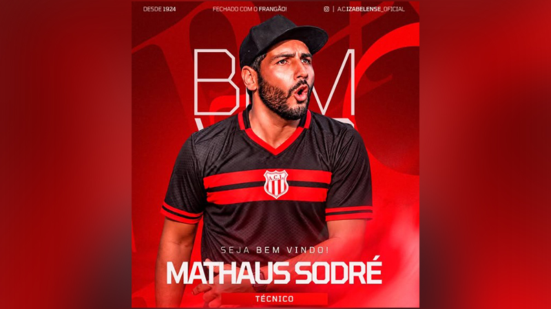 Homem com barba e boné vestindo camisa preta e vermelha com escudo de time de futebol.