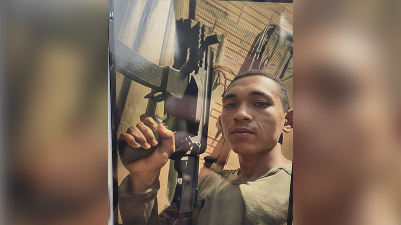 Homem jovem segurando uma arma de fogo.