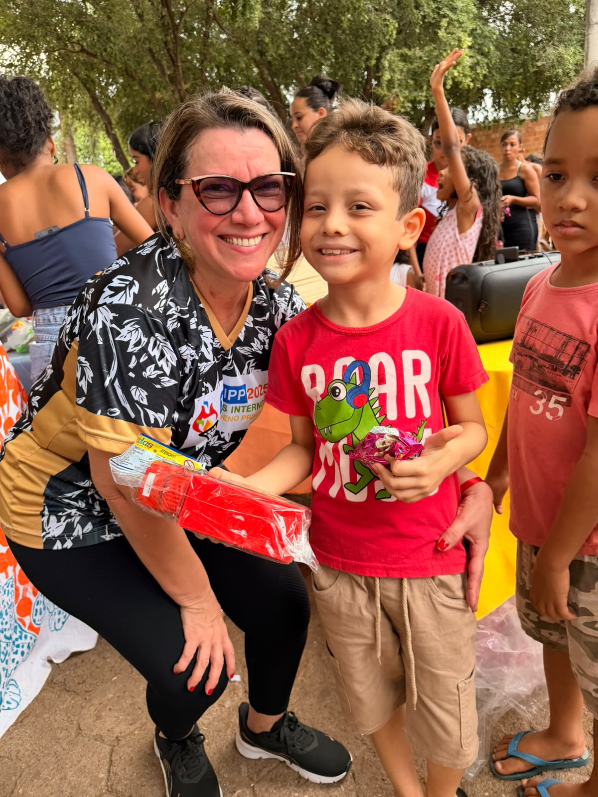 Orientadora pedagógica e idealizadora do projeto, Mariana Moura entrega presente para uma criança do bairro