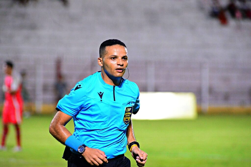 Árbitro de futebol brasileiro vestindo uniforme azul com o emblema da CBF em campo