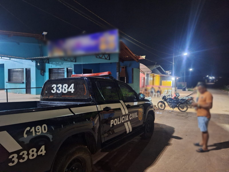 Viatura da Polícia Civil estacionada em frente a um estabelecimento comercial durante a noite