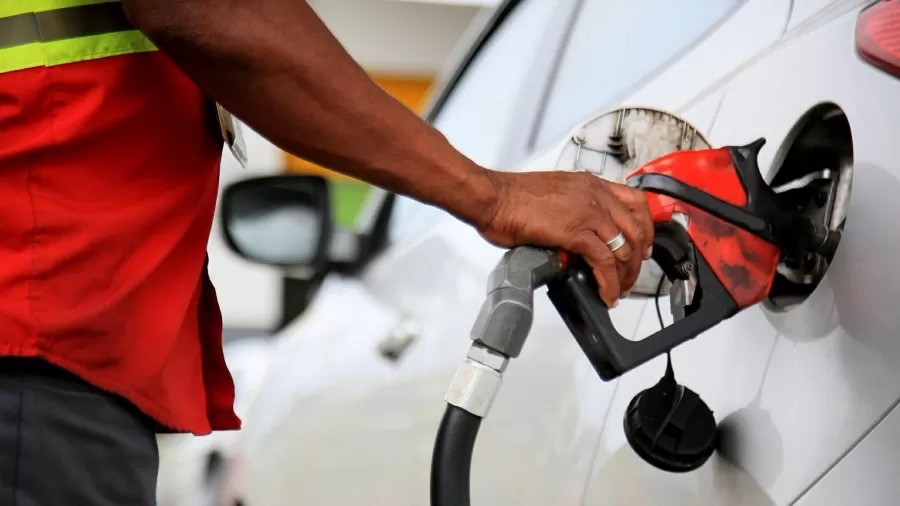 Frentista abastecendo um carro em um posto de combustível