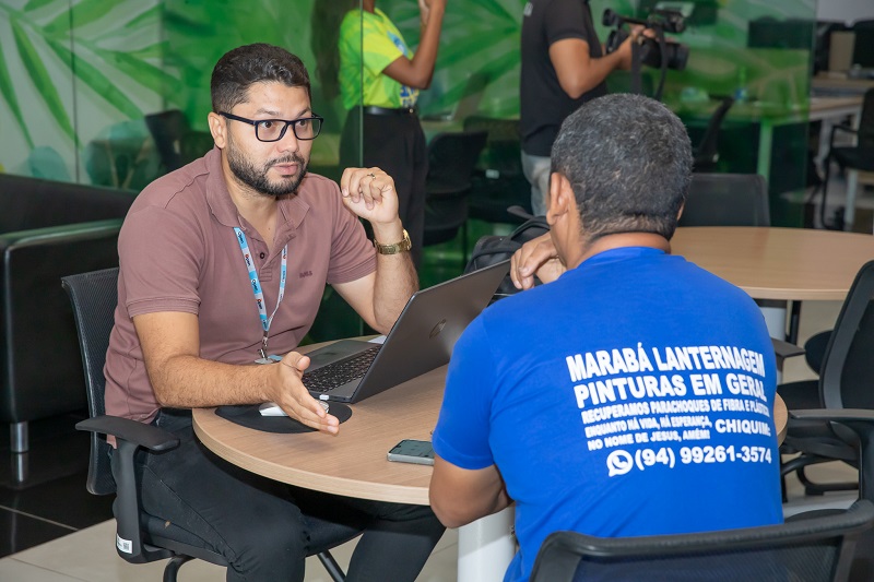 Homem de óculos conversando com cliente em escritório